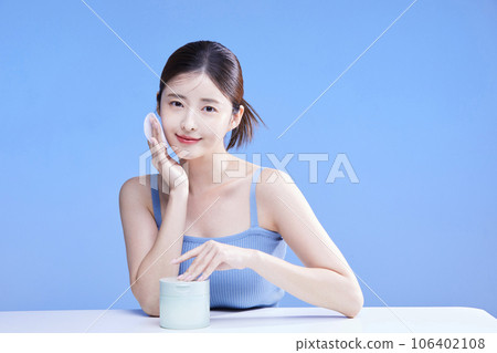 beauty concept photo of korean asain beautiful woman holding cleansing pads alongside a product 106402108