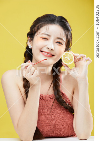 beauty concept photo of korean asain beautiful woman holding a lipgloss and a lemon beauty concept photo of korean asain beautiful woman holding a lipgloss and a lemon 106402238