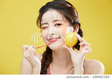 beauty concept photo of korean asain beautiful woman holding a lipgloss and a lemon 106402269