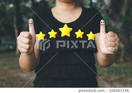 a woman thumbs up on the happy Smiley face icon and five star to give satisfaction in service.rating very impressed.Customer service and Satisfaction concept a woman thumbs up on the happy Smiley face icon and five star to give satisfaction in service.rating very impressed.Customer service and Satisfaction concept 106403146