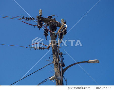 Electrification. A pole entangled with many wires. Power pole. Old technologies. Electrification. A pole entangled with many wires. Power pole. Old technologies. 106403588