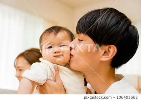 A man in his 30s who kisses a 0-year-old baby A man in his 30s who kisses a 0-year-old baby 106403668