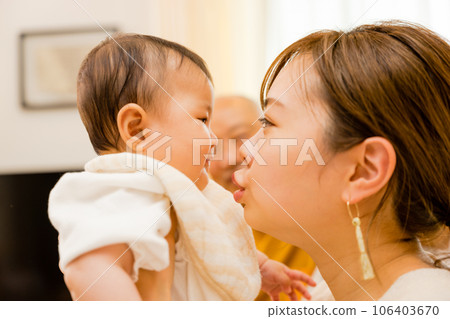 A Japanese mother in her 20s to 30s cradles her 0-year-old baby and brings her face close to it. A Japanese mother in her 20s to 30s cradles her 0-year-old baby and brings her face close to it. 106403670