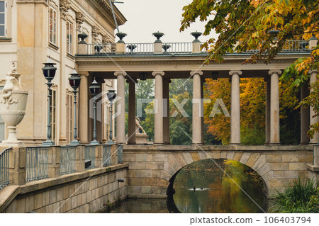 Baths classicist Palace on the Isle in Lazienki Park touristic place in Warsaw. Lazienki Royal Baths Park, Baroque columns Warsaw Poland. Colorful Autumn Foliage and Mirror Reflection on the Lake 106403794