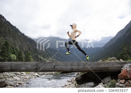Woman trail runner cross country running in high altitude mountains 106403837