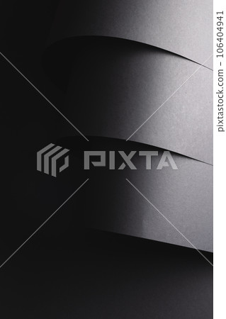 Vertical image of close up of layers of pieces of black paper with copy space on black background Vertical image of close up of layers of pieces of black paper with copy space on black background 106404941