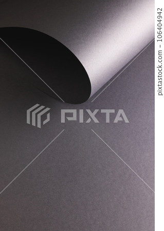 Vertical image of close up of rolled up piece of black paper with copy space on black background Vertical image of close up of rolled up piece of black paper with copy space on black background 106404942