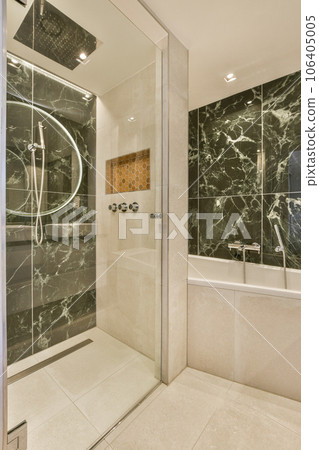 a modern bathroom with marble walls and tile flooring in the shower stall is shown to the right, there is a large mirror a modern bathroom with marble walls and tile flooring in the shower stall is shown to the right, there is a large mirror 106405005