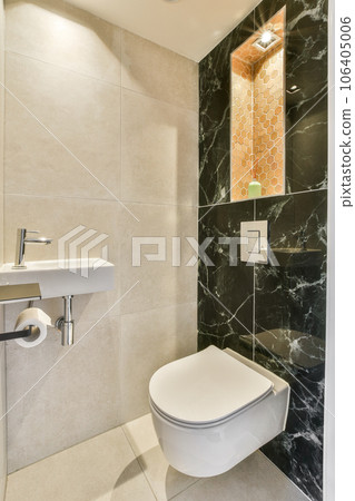 a bathroom with black and white marble on the walls, along with a toilet in the wall is decorated with an orange mosaic tile a bathroom with black and white marble on the walls, along with a toilet in the wall is decorated with an orange mosaic tile 106405006