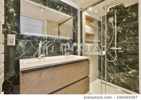 a modern bathroom with black marble walls and flooring, along with a walk - in shower stall on the right side a modern bathroom with black marble walls and flooring, along with a walk - in shower stall on the right side 106405007