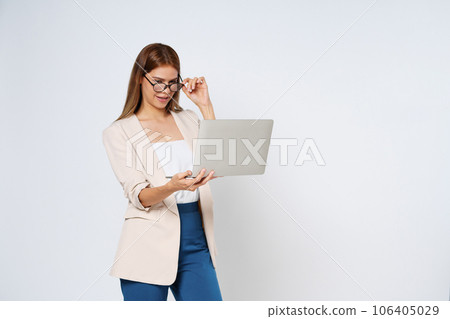 Businesswoman holding a laptop while standing isolated on white background. Businesswoman holding a laptop while standing isolated on white background. 106405029