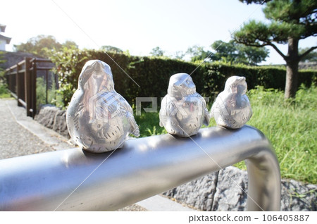 Statue of a sparrow perched on a fence 106405887