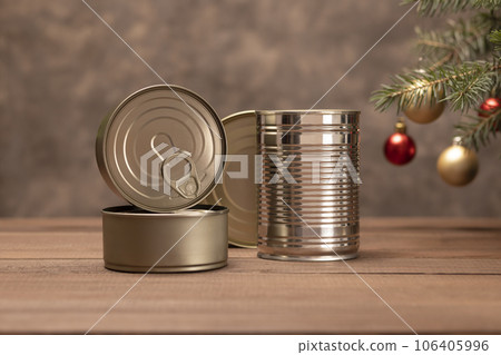 Christmas canned preserved food, products, packed fish, meat, seafood or vegetables in can on wooden table Christmas tree and toy balls. Copy space. New Year food concept. Horizontal Plane Christmas canned preserved food, products, packed fish, meat, seafood or vegetables in can on wooden table Christmas tree and toy balls. Copy space. New Year food concept. Horizontal Plane 106405996