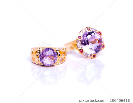 Closeup display of two exquisite rings adorned with gleaming amethyst stones, elegantly positioned on a pure white backdrop; radiating luxury, romance, and aesthetic beauty. Closeup display of two exquisite rings adorned with gleaming amethyst stones, elegantly positioned on a pure white backdrop; radiating luxury, romance, and aesthetic beauty. 106406418