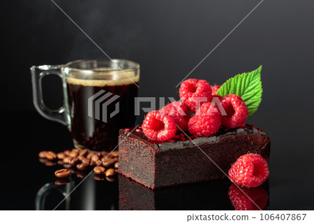 Chocolate cake with fresh raspberries and black coffee. 106407867