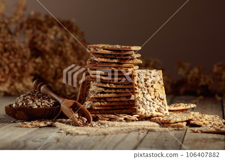 Crackers with sunflower and flax seeds on an old wooden table. 106407882