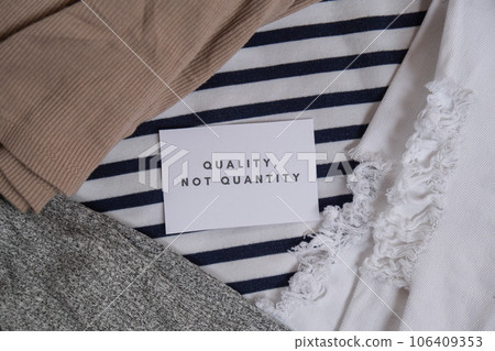 Quality not quantity text on paper note on clothes assortment Second hand sustainable shopping. Capsule minimal wardrobe. Sustainable fashion overconsumption, conscious buying consumption, slow 106409353