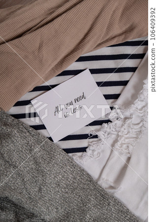 ALL YOU NEED IS LESS text on paper note on clothes assortment Second hand sustainable shopping. Capsule minimal wardrobe. Sustainable fashion overconsumption, conscious buying consumption, slow 106409392