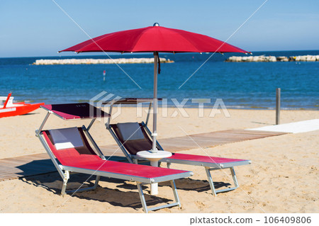 Parasol umbrella on tropical island beach. Colourful sunshade in the beach on sunny summer day. Holiday relaxation with turquoise sea and blue sky landscape Parasol umbrella on tropical island beach. Colourful sunshade in the beach on sunny summer day. Holiday relaxation with turquoise sea and blue sky landscape 106409806