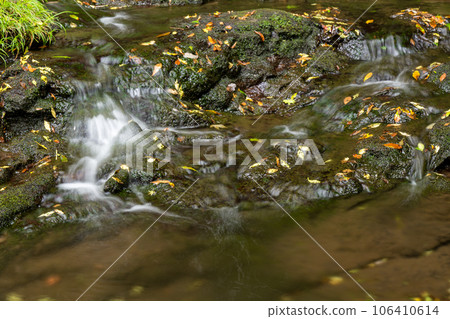 A waterfall leading to the Kikuchi Gorge with a clear stream flowing through nature A waterfall leading to the Kikuchi Gorge with a clear stream flowing through nature 106410614