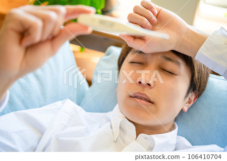 一個感冒的男人,一個發燒的男人和溫度計 一個感冒的男人,一個發燒的男人和溫度計 106410704