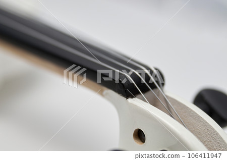 Headstock and pegs of a white violin close-up 106411947