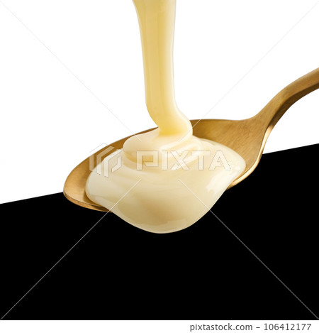 condensed milk pouring into spoon condensed milk pouring into spoon 106412177