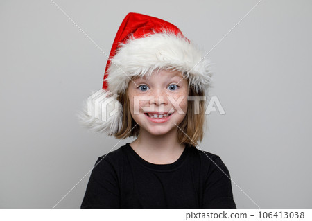 Christmas child girl in Santa hat looking at camera on white background, Xmas portrait Christmas child girl in Santa hat looking at camera on white background, Xmas portrait 106413038