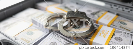 Handcuffs on pile of cash in suitcase Handcuffs on pile of cash in suitcase 106414874