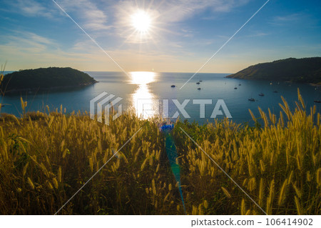 Sunset on Phuket island viewpoint turquoise sea water with yellow grass Sunset on Phuket island viewpoint turquoise sea water with yellow grass 106414902