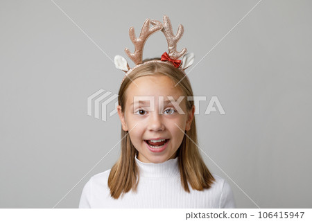 Christmas surprised child girl in Xmas hair deco on white background Christmas surprised child girl in Xmas hair deco on white background 106415947