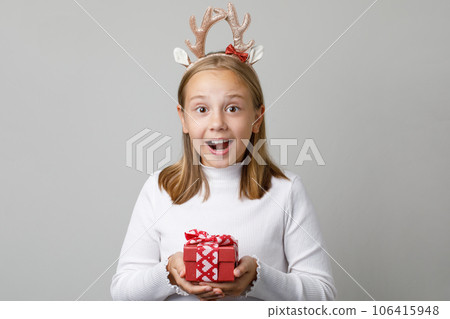 Happy Christmas child girl holding red Xmas present gift on white background 106415948