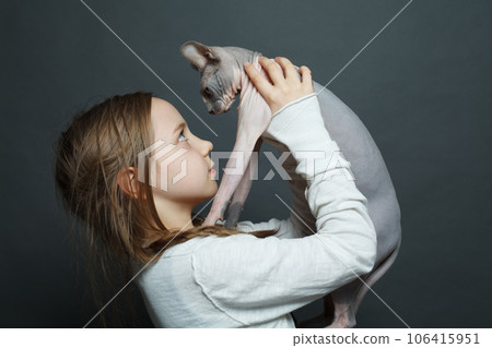 Cute child girl holding cat on blue background, studio portrait 106415951