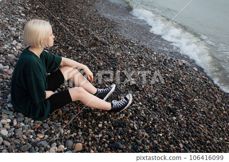 Young blonde woman relaxing near sea outdoors 106416099