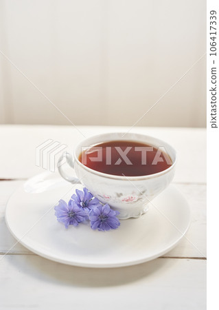 The composition of the drink from chicory, cups and saucers on a wooden table with space for copying. A healthy drink made from chicory. High quality photo The composition of the drink from chicory, cups and saucers on a wooden table with space for copying. A healthy drink made from chicory. High quality photo 106417339