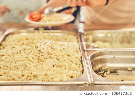 I put boiled pasta in a plate with vegetables. Vegetarian food. Buffet at the hotel on vacation. High quality photo 106417368