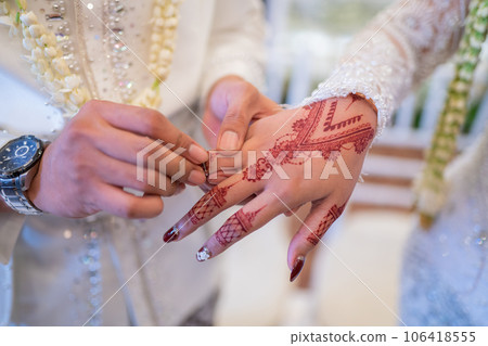 Married couple put wedding rings in a traditional Indonesian wedding ceremony Married couple put wedding rings in a traditional Indonesian wedding ceremony 106418555