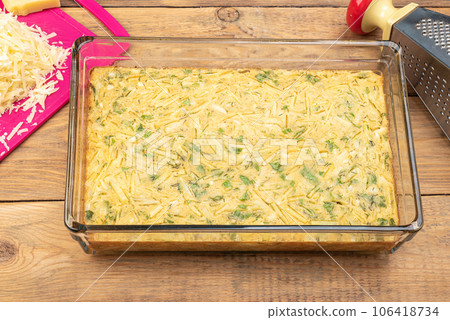 Unsweetened burek baked burek, grated cheese and grater on a wooden background. 106418734