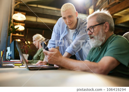 Business people, colleagues working on new project together in office. Young man helping senior people Business people, colleagues working on new project together in office. Young man helping senior people 106419294