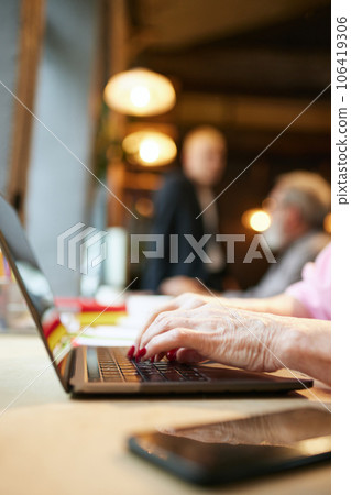 Female hands typing on laptop. Business people, colleagues, senior and young co-workers. Modern office 106419306