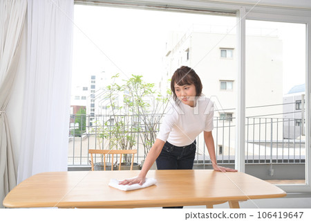 A woman wiping the table with a cloth A woman wiping the table with a cloth 106419647
