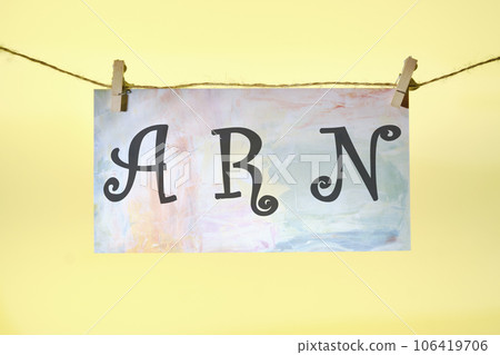 ARN as Account Reference Number written lettering on colored paper hanging in front of a yellow background with a rope and clothespins 106419706