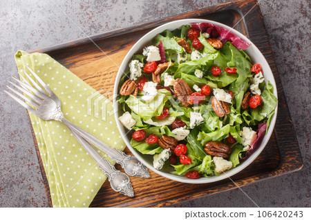 Michigan Cherry Salad with greens, blue cheese and pecan tossed with a vinaigrette dressing closeup on the plate. Horizontal top view 106420243