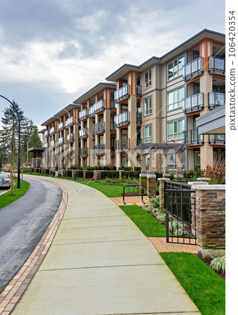Residential apartment building with walking pathway in front Residential apartment building with walking pathway in front 106420354