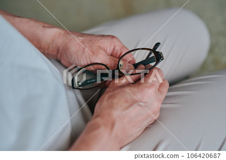 Senior woman's hand with glasses Senior woman's hand with glasses 106420687