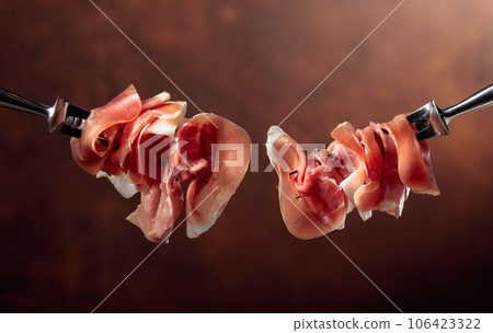 Prosciutto on a fork. 106423322
