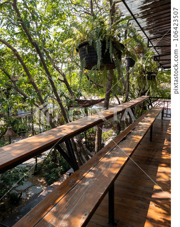 The wooden terrace with the long bench and tropical plant. 106423507