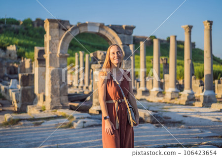 Pretty tourist woman at the ruins of ancient city of Perge near Antalya Turkey 106423654