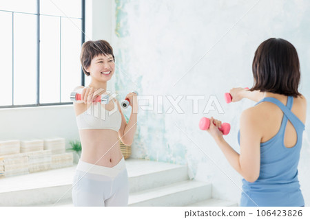 A young woman training with a dumbbell A young woman training with a dumbbell 106423826