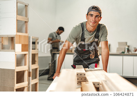 Portrait of young male carpenter standing in the wood workshop 106424871